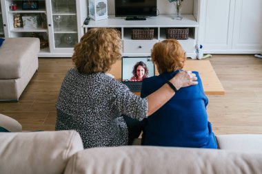 Evde dizüstü bilgisayarda video sohbeti yapan kadınlar