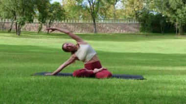 Nilüfer çiçeğinde oturup yoga yapan sağlıklı atletik bir kadın başlarını sağa sola eğip, meditasyon sırasında namaste Mudra 'da el kaldırıyor.