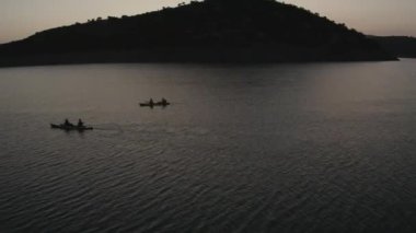 Günbatımında nehirde yüzen turistler 