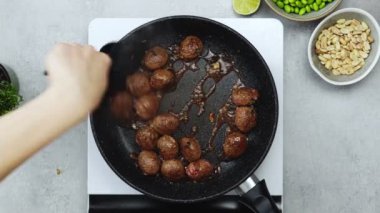 Kimliği belirsiz bir kadının köfteye dönüşmesi, mutfakta tezgahta yemek pişirirken elektrikli fırında kızarması.