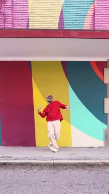 Cansız vücut sakallı erkek dansçı şık giysiler içinde kaldırımda gösteri yaparken.