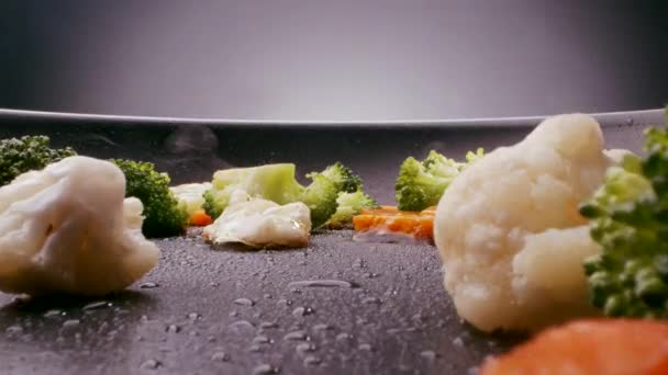在蒸汽慢速热金属油锅上 用胡萝卜和花椰菜配制绿色花椰菜 使其变焦 — 图库视频影像