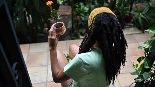 非洲美女用小植物装饰壶的衣服 — 图库视频影像