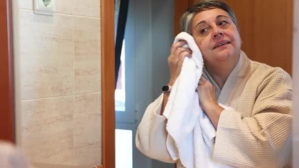 Donna Mezza Età Accappatoio Guardando Specchio Asciugando Viso Durante Routine — Video Stock