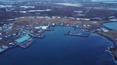 İzlanda 'daki bulutlu gökyüzüne karşı sakin deniz kıyısındaki kasaba liman binalarının hava manzarası