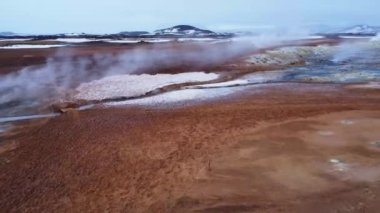 Soğuk kış gününde İzlanda, Reykjahlid 'de karla kaplı Hver jeotermal alanının engebeli yüzeyi.