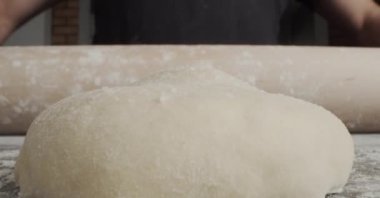 Adam mutfakta pizza pişiriyor.