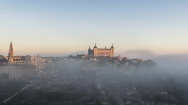 Antik şehir ve ortaçağ Alcazar de Toledo sarayının renkli şafak vakti sisli görüntüsü