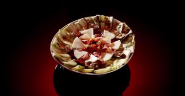 İştah açıcı aromatik ince pizza ızgara kabaklı ve domatesli patlıcan ve mantarlı koyu kırmızı arka planda servis ediliyor.