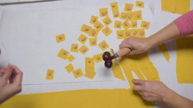 Mutfaktaki masada lezzetli geleneksel tortellini pişirirken yaşlı bir kadın hamuru kesiyor.