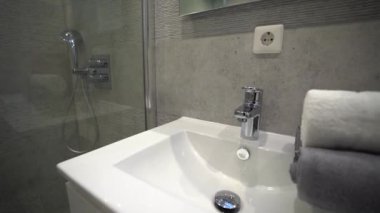 Modern banyodan el havzası ve duvar kaplamalı duş kabini ile minimal bir şekilde uzaklaşın.