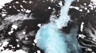 İzlanda 'da kasvetli bir günde kayalık kayalıklardan akan güçlü şelalenin nefes kesici manzarası.