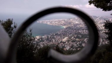 Lübnan 'da güneşli bir günde deniz kenarındaki tatil beldeleri ve konut binalarıyla Jounieh sahil şehrinin manzaralı manzarası.