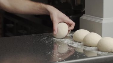 Adam mutfakta pizza pişiriyor.