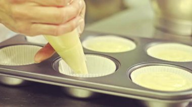 Mutfakta çalışırken pasta poşeti ve kek pişirme formunu hamurla doldurarak tanınmayacak hale getirilmiş profesyonel kadın pastacı.