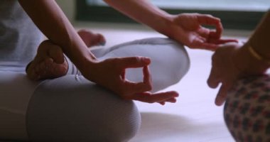 Aktif çalışan genç sporcu kadınlar yoga yapıyor ve sabahları geniş stüdyoda farklı esneme hareketleri yapıyorlar.