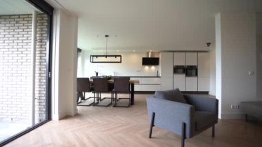 Ahşap masa, tezgahın yanında sandalyeler ve ev yemekhanesi olan güneşli mutfaktaki aletler.