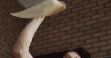 Adam mutfakta pizza pişiriyor.