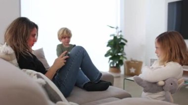 Gerçek zamanlı anne sörfü tableti. Oturma odasında kanepede otururken kızgın oğlunun oyuncağını alırken.