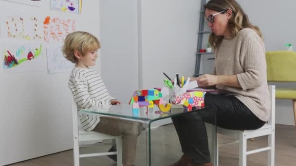 Γυναίκα Ψυχολόγος Κάθεται Κοντά Αγόρι Σχέδιο Χαρτί Στο Τραπέζι Κοντά — Αρχείο Βίντεο