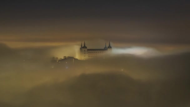 輝く古代アルカサル トレドの素晴らしい景色の上から霧の薄明かりの中で町の上に城 — ストック動画