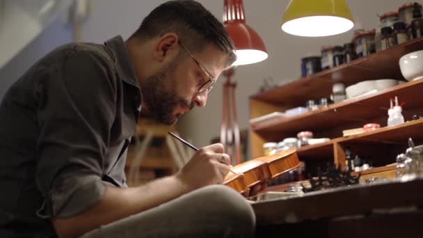 Vista Lateral Artesão Adulto Óculos Sentados Mesa Luthiery Coloração Montado — Vídeo de Stock