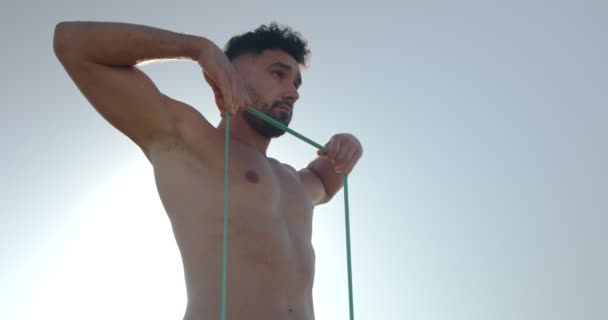 Muscular Male Bodybuilder Naked Torso Standing Seashore Doing Exercises Resistance — Stock Video