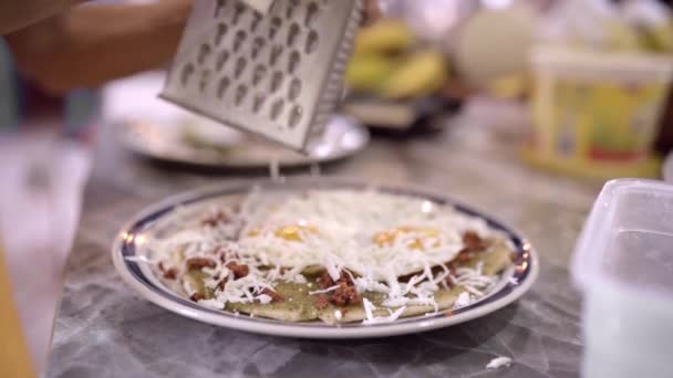 サイドビュー ライトキッチンでプレートで提供される卵とナチョスと皿に匿名の調理チーズをクロップ — ストック動画