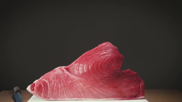 亚洲餐馆的大块蓝鳍金枪鱼肉放在刀刃附近的桌子上 — 图库视频影像