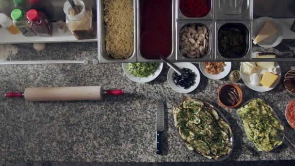 토마토 소스와 야채를 부엌에서 재료와 식기와 대리석 카운터에 추가하는 포함하여 — 비디오