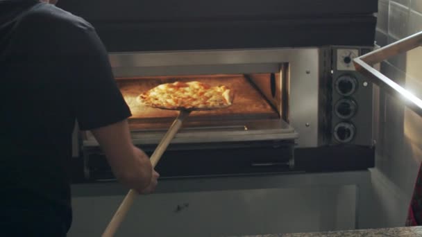 Zbliżenie Anonimowy Pizzaiolo Otwierając Gorący Piekarnik Obracając Pizzę Łopatą Podczas — Wideo stockowe