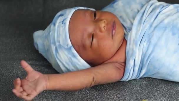 静かな愛らしい眠い新生児寝そべっている青い居心地の良い毛布に包まれて — ストック動画