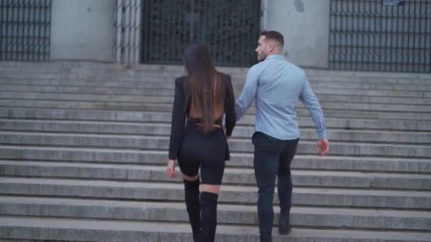 ロマンチックなスタイリッシュなカップルが街の日付中にストーン階段を歩きながら手を握るリアルタイム — ストック動画