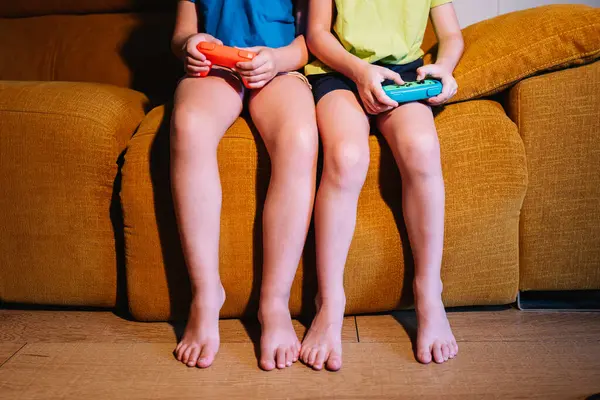 Ritagliato Fratelli Irriconoscibili Con Pastiglie Gioco Giocare Videogioco Mentre Seduto — Foto Stock