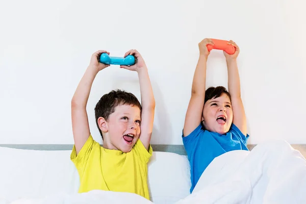 Conteúdo Irmãos Levantando Braços Com Almofada Jogo Emoção Enquanto Jogam — Fotografia de Stock