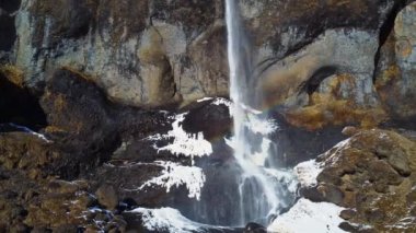 Soğuk kış gününde İzlanda 'nın doğasında kayalıklardan düşen temiz bir şelale.