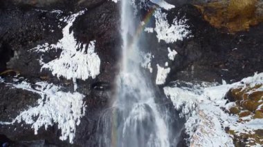 Soğuk kış gününde İzlanda 'nın doğasında kayalıklardan düşen temiz bir şelale.
