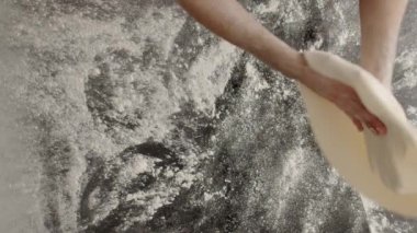 Adam mutfakta pizza pişiriyor.