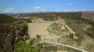 İHA, Francisco Abellan rezervuarının devasa barajını ve turkuaz suyunu güneş ışığında yeşil dağlarla görüyor.