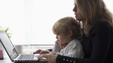 Anne ve oğlu dizüstü bilgisayarın başında oturuyorlar..