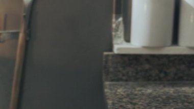 Anonim bir fırıncı fırın mutfağında çalışırken biberiyeli ve tuzlu gevrekli Focaccia hamuru fırına koyar.