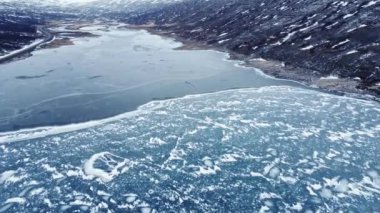 İzlanda 'nın bulutlu bir gününde Vatnajokull Ulusal Parkı' nın volkanik arazisinde karlı dağlarla çevrili denizde yüzen buz parçalarının manzarası.