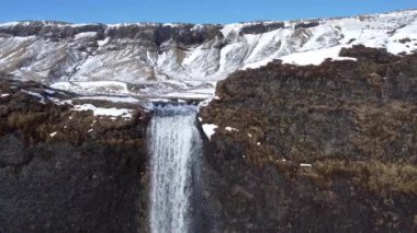 Soğuk kış gününde İzlanda 'nın doğasında kayalıklardan düşen temiz bir şelale.