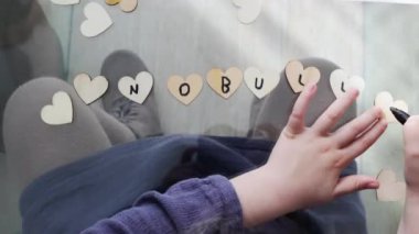 Küçük kalplere zorbalık yapılmadan odada cam masada oturan isimsiz bir çocuğun yazı yazışının en üst görüntüsü