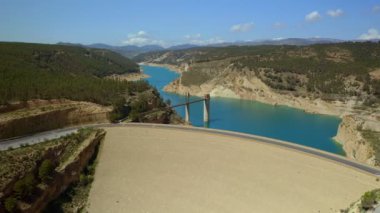 İHA, Francisco Abellan rezervuarının devasa barajını ve turkuaz suyunu güneş ışığında yeşil dağlarla görüyor.