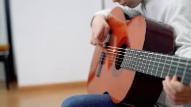 Gitar çalan sevimli çocuğa yakın çekim. Çocuklar için müzik okulu