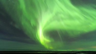 Norveç 'te kışın karla kaplı dağların üzerinde parıldayan mor ve yeşil aurora borealis ile muhteşem bir gece.