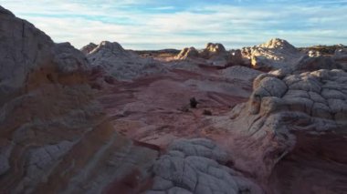 Arizona 'da günbatımı gökyüzünün altındaki Vermilion Cliffs Ulusal Anıtı' nın Beyaz Cebi 'ndeki pürüzsüz kumtaşı tepelerinin muhteşem hava manzarası.