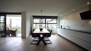 Ahşap masa, tezgahın yanında sandalyeler ve ev yemekhanesi olan güneşli mutfaktaki aletler.