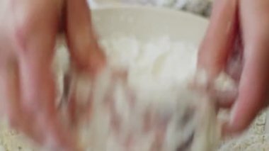 Geleneksel İtalyan ossobuco pişirirken çiğ dana inciğini un ile kaplayan isimsiz bir kadının gerçek zamanlı yüksek açılı görüntüsü.